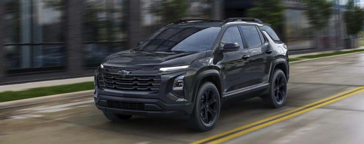 A black 2025 Chevy Equinox LT Midnight Edition is shown driving on a city street.