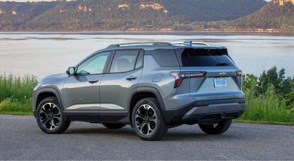 The rear and side of a grey 2025 Chevy Equinox LT parked near a lake.