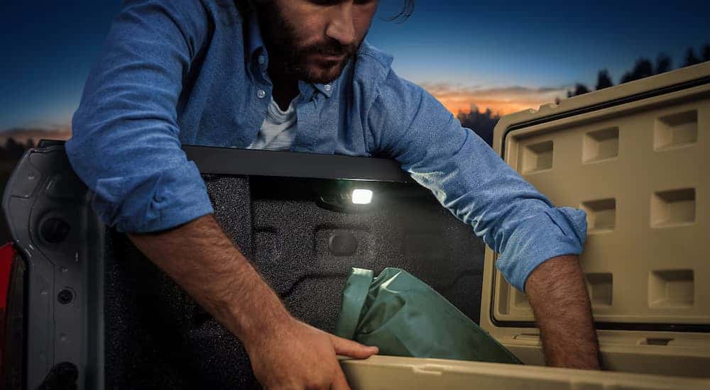 A man is leaning into the bed of a 2025 Chevy Colorado.