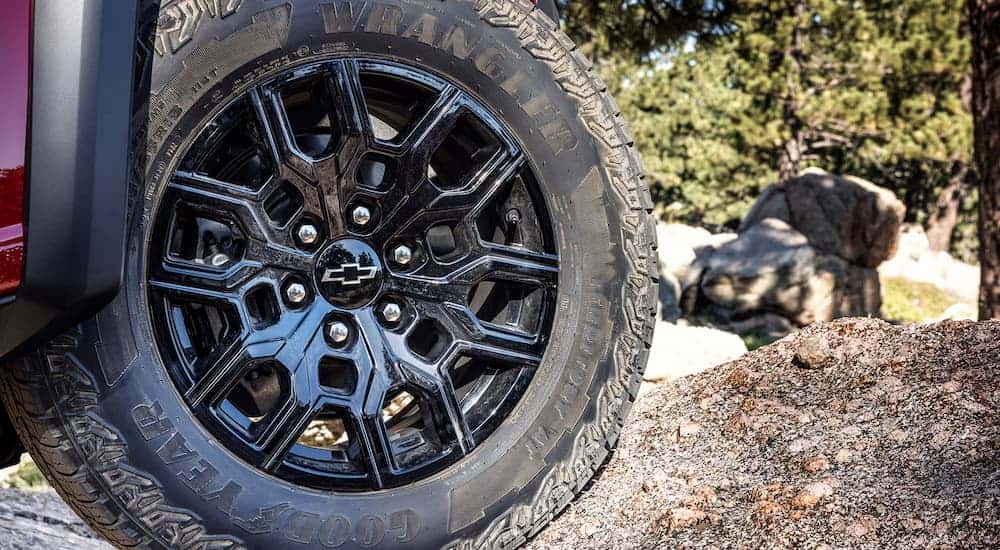 The black rim and tire on a red 2025 Chevy Colorado Trailboss.