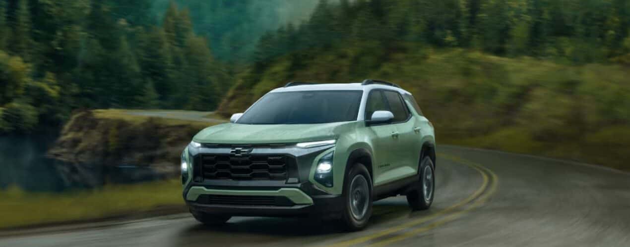 A green 2025 Chevy Equinox ACTIV driving during a rainstorm.