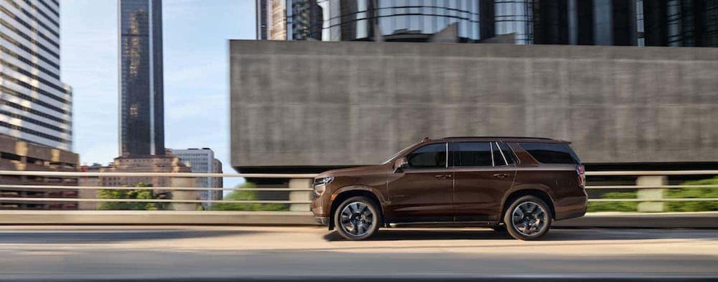 A brown 2022 used Chevy Tahoe for sale is shown from the side.