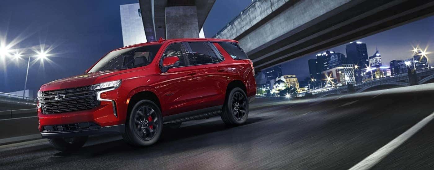 A red 2023 Chevy Tahoe for sale is shown from the side.