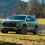 A green 2025 Chevy Equinox ACTIV parked on grass.
