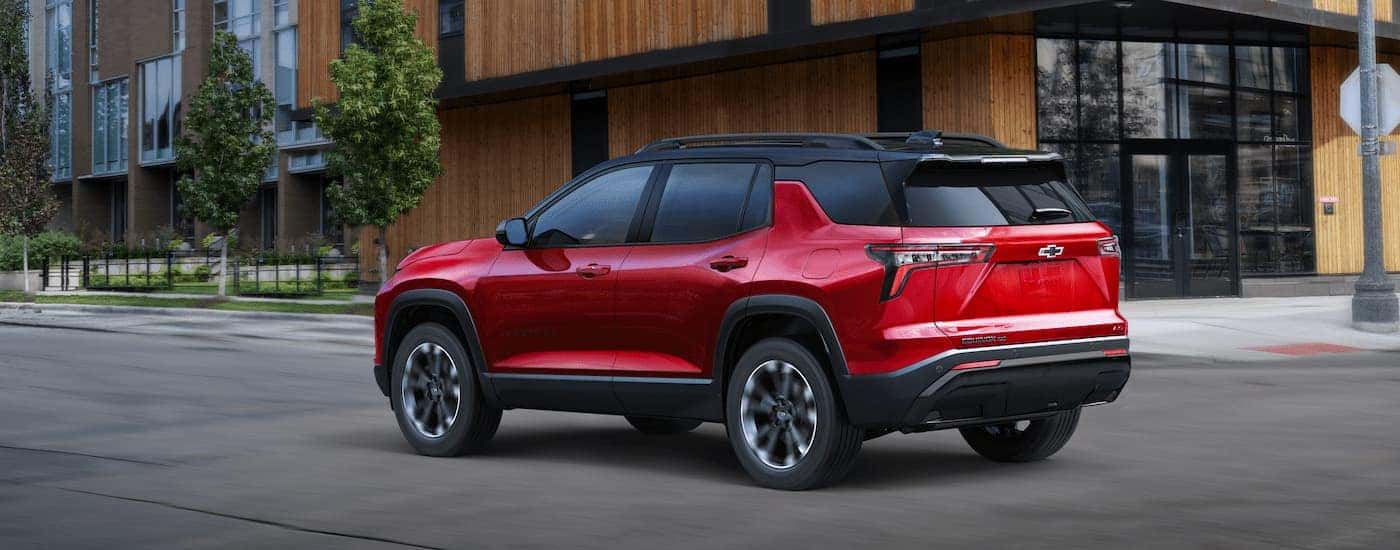 Red 2025 Chevy Equinox RS driving in a city.