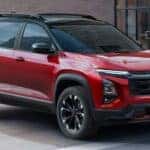 A red 2025 Chevy Equinox RS driving in a city.