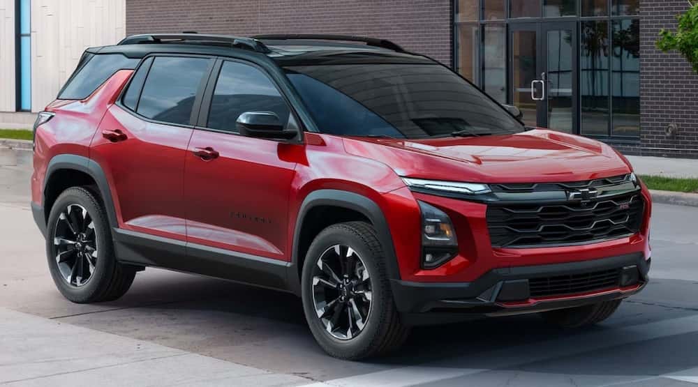 A red 2025 Chevy Equinox RS driving in a city.