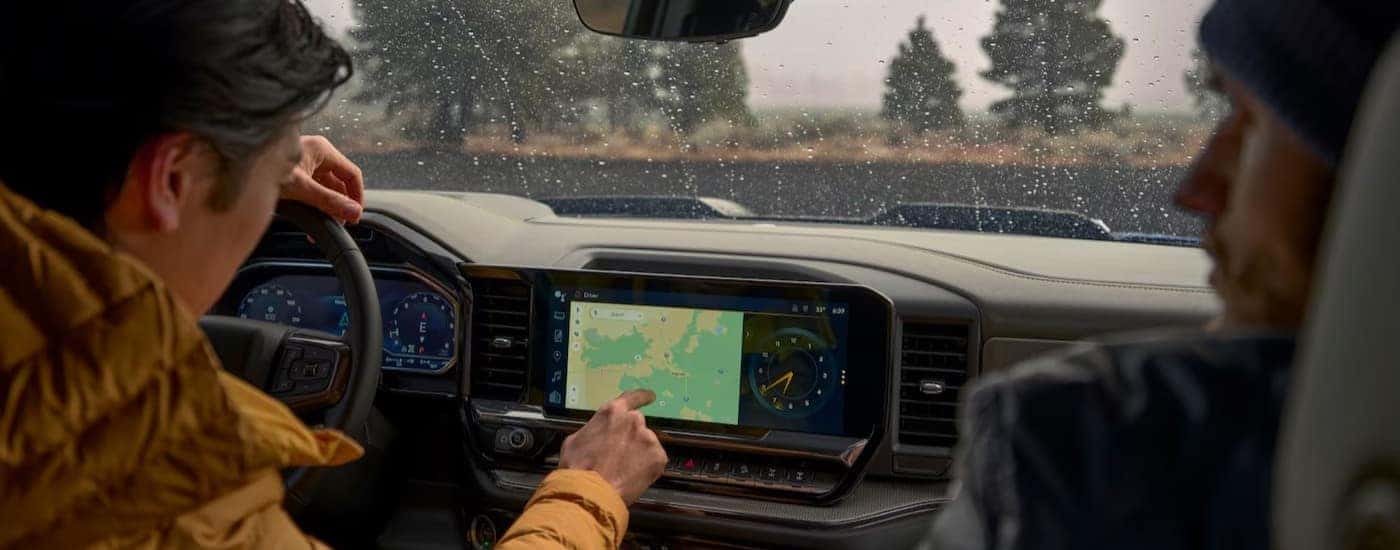 A person touching the infotainment screen in a 2025 Chevy Silverado 1500 LT.