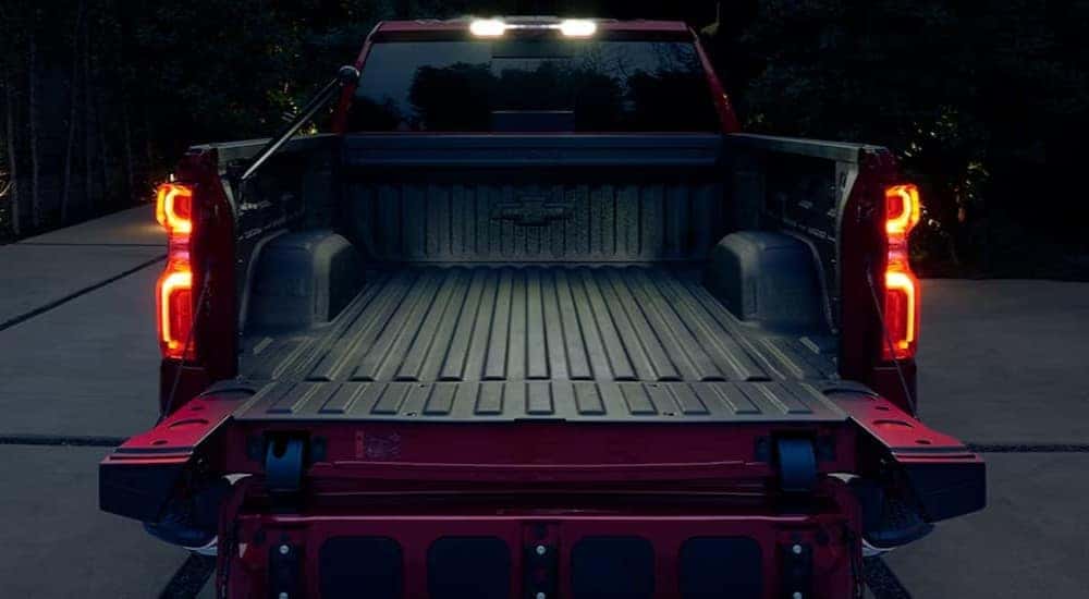 Rear view of a red 2025 Chevy Silverado 1500 LT with an open tailgate.