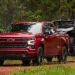 A red 2025 Chevy Silverado 1500 RST parked off-road.