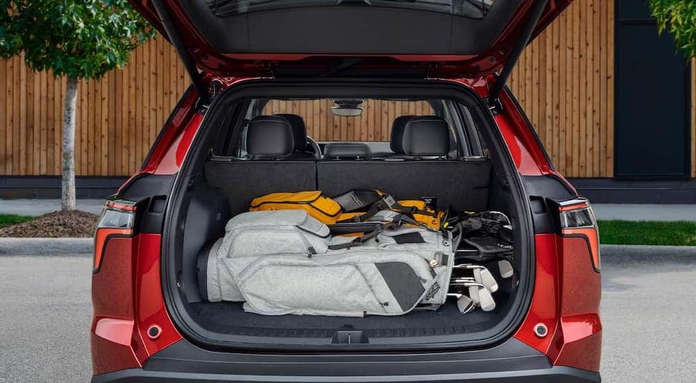 Rear view of a red 2025 Chevy Equinox with an open hatchback.