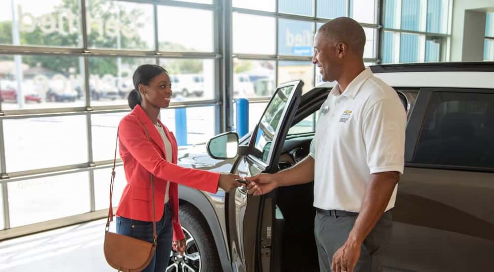 Two people shaking hands at a dealership.