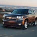 A used black 2021 Chevy Tahoe for sale driving on a highway.