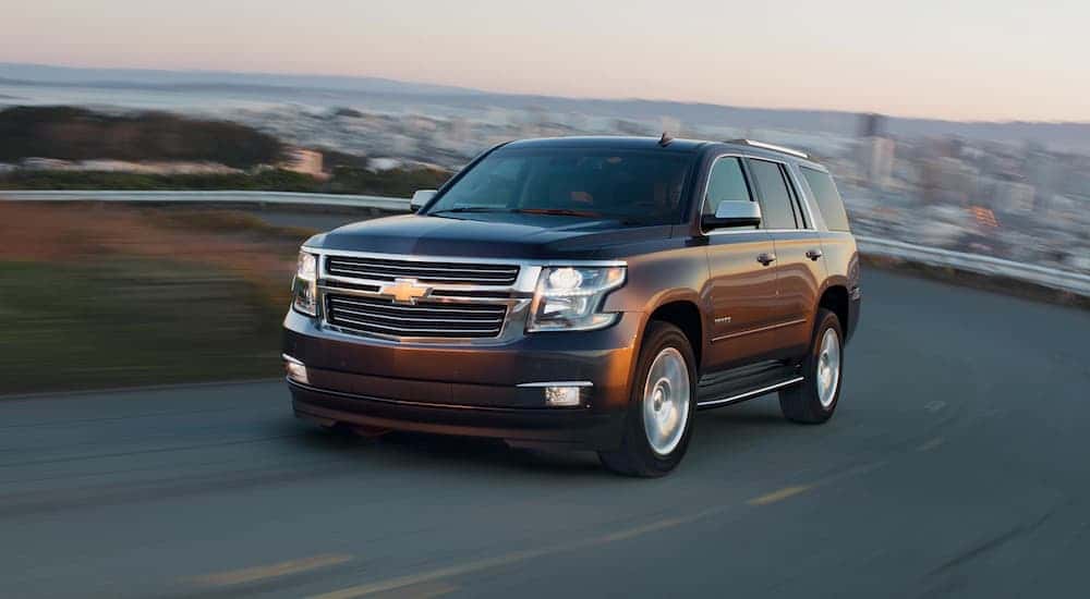 A used black 2021 Chevy Tahoe for sale driving on a highway.
