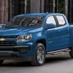 A blue 2022 used Chevy Colorado for sale parked in a city.