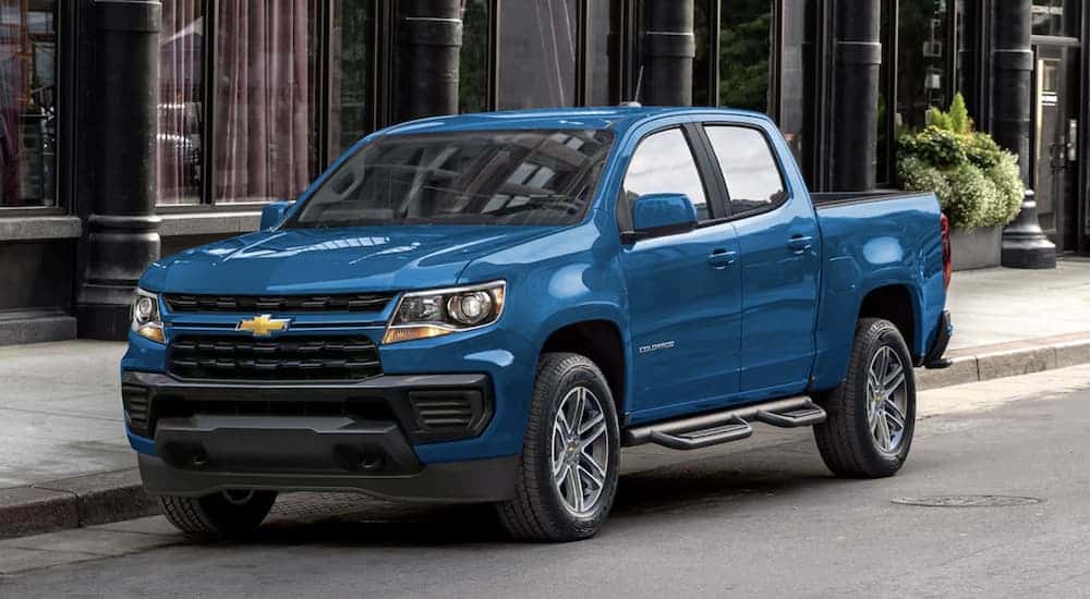 A blue 2022 used Chevy Colorado for sale parked in a city.
