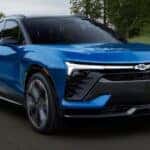 Blue 2025 Chevy Blazer EV driving on a winding road.