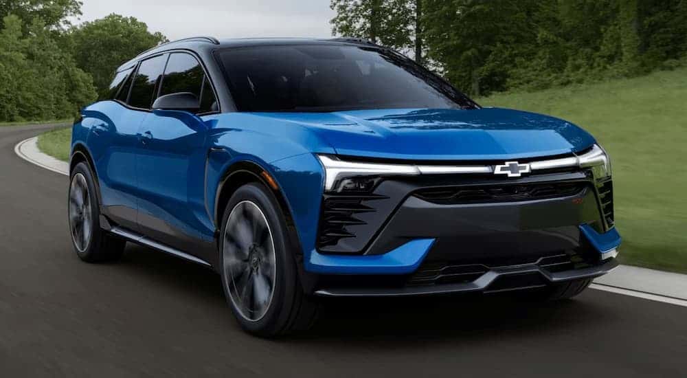 Blue 2025 Chevy Blazer EV driving on a winding road.