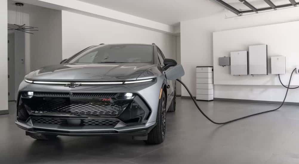 A gray 2025 Chevy Equinox EV RS charging in a garage.
