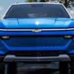A blue 2025 Chevy Equinox EV parked near water.