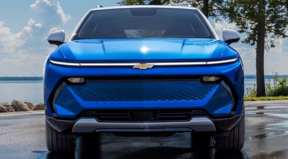 A blue 2025 Chevy Equinox EV parked near water.