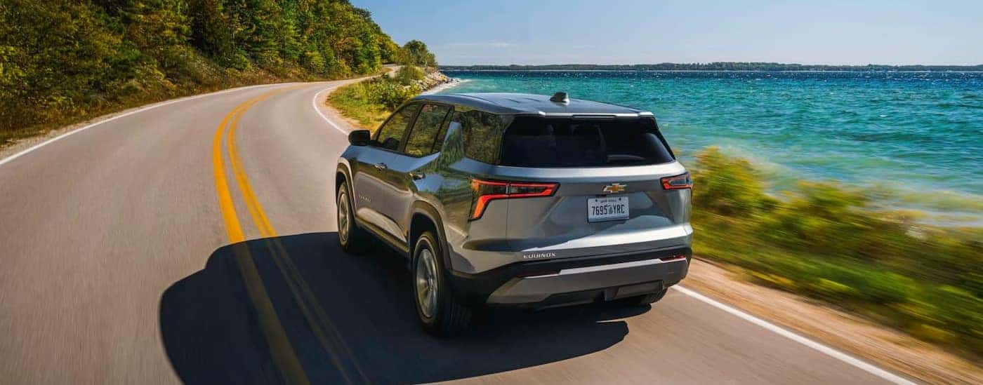 A silver 2026 Chevy Equinox driving near an ocean.
