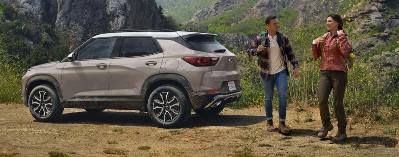 Hikers standing near a tan 2026 Chevy Trailblazer.