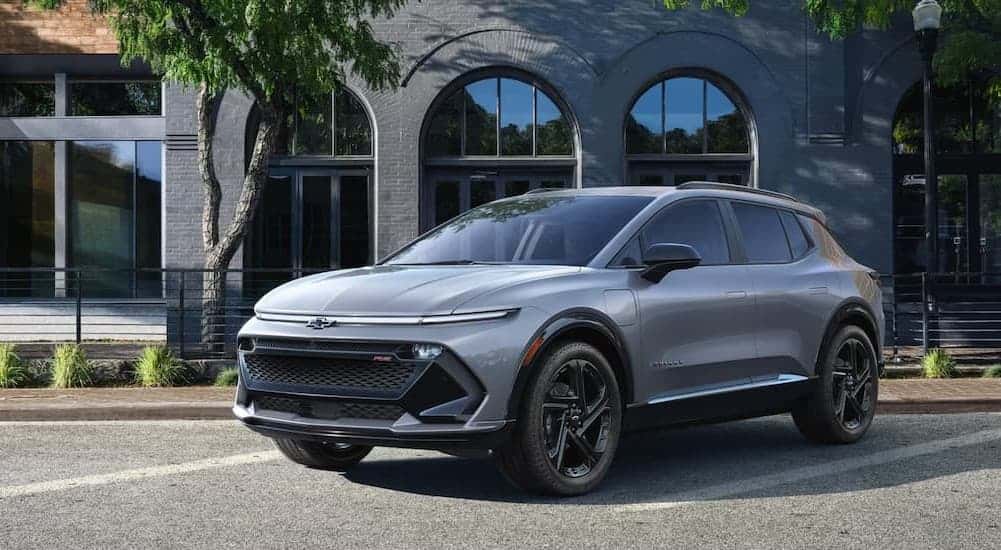 A silver 2025 Chevy Equinox EV RS parked in a city.