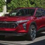 A red 2025 Chevy Trax RS is parked in a city.