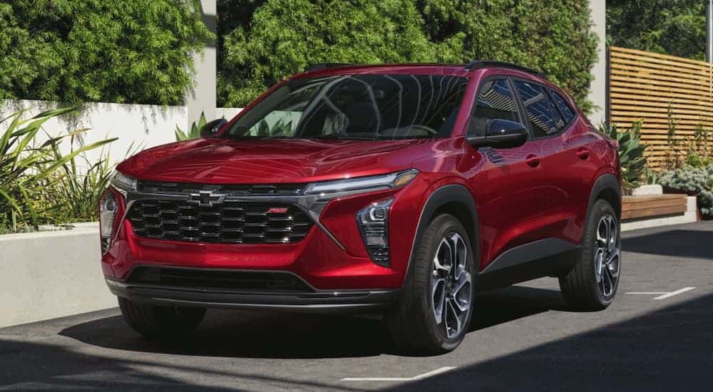 A red 2025 Chevy Trax RS is parked in a city.