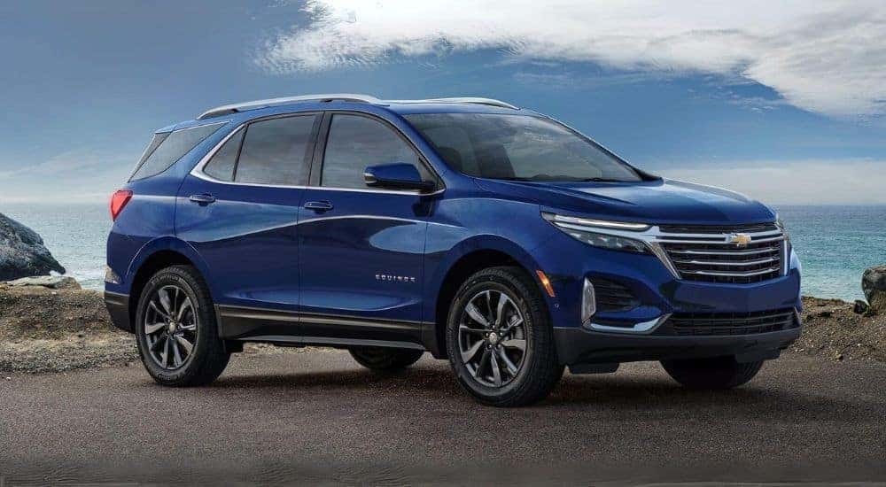 Blue 2023 Chevy Equinox parked on gravel.
