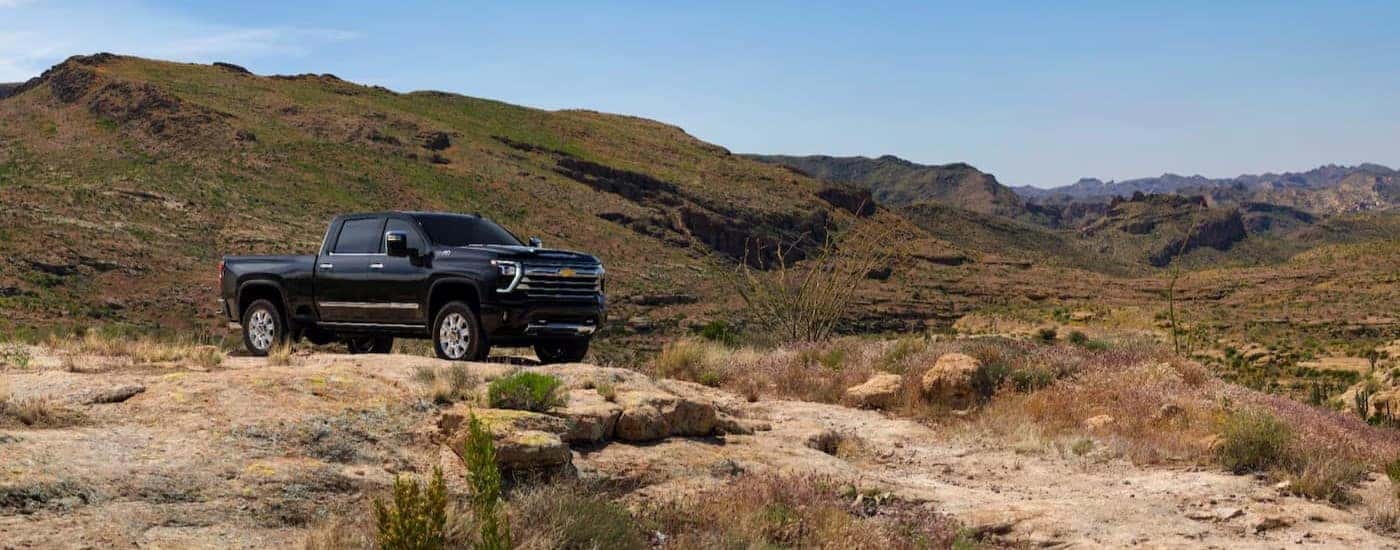 A black 2025 Chevy Silverado 2500 HD High Country parked off-road.