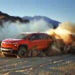 A red 2025 Chevy Silverado EV trail Boss off-roading.