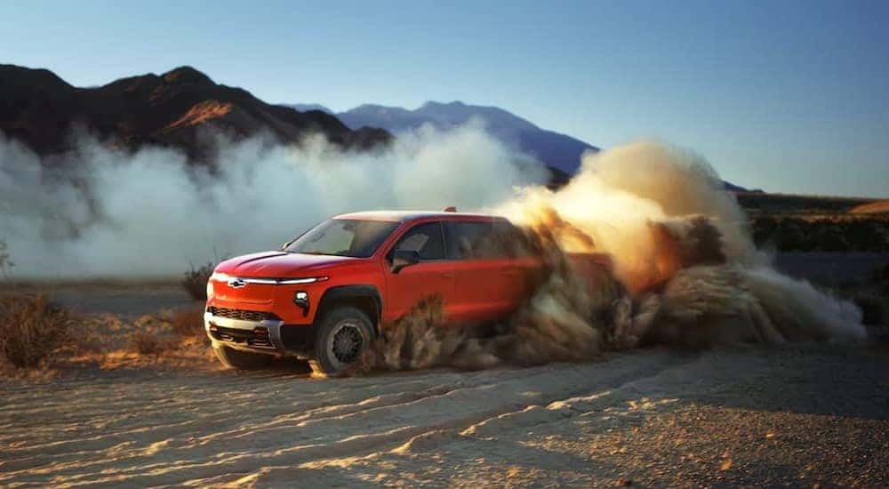 A red 2025 Chevy Silverado EV trail Boss off-roading.