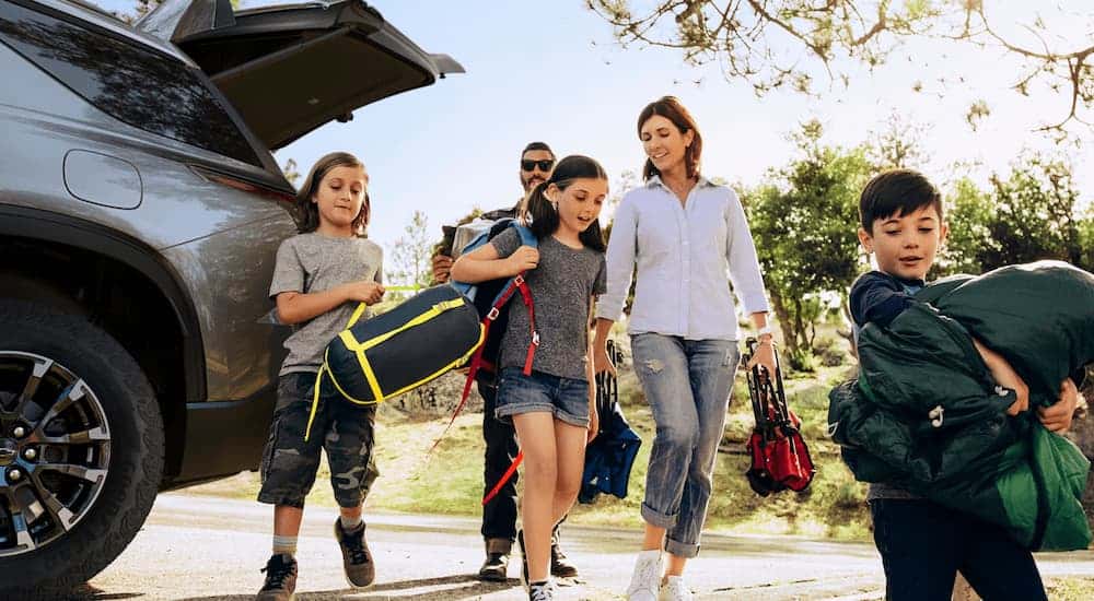 Family with camping gear walking away from a 2025 Chevy Traverse
