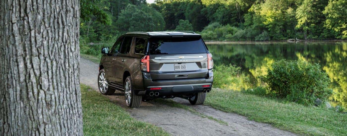 A gray 2021 Chevy Tahoe driving near a pond.