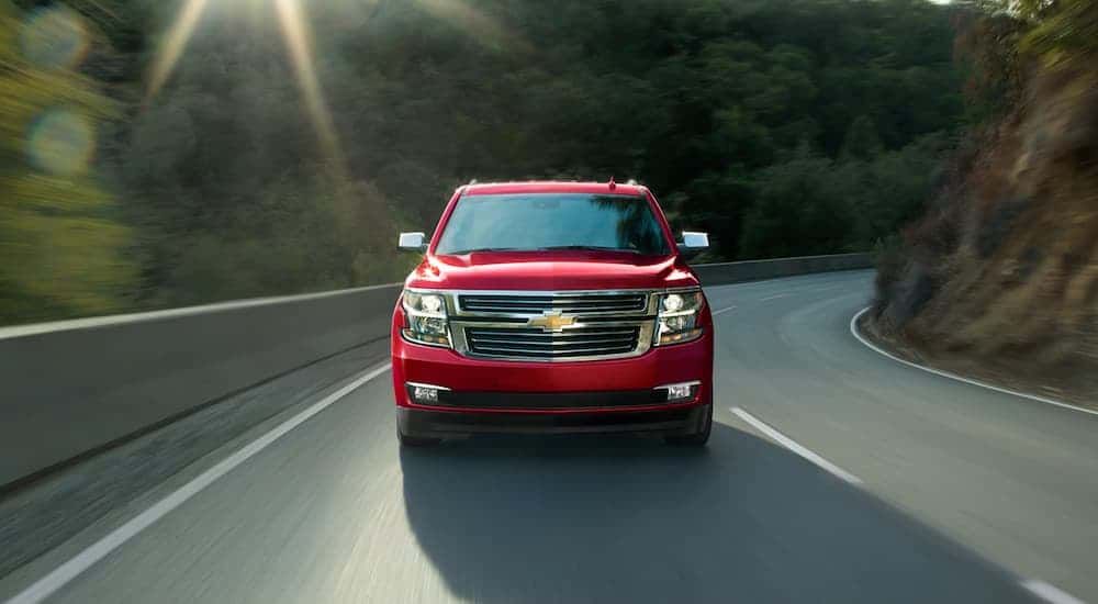 A red 2020 Chevy Tahoe for sale in Albany driving on a highway.