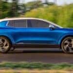 A blue 2025 Chevy Equinox EV driving down a street