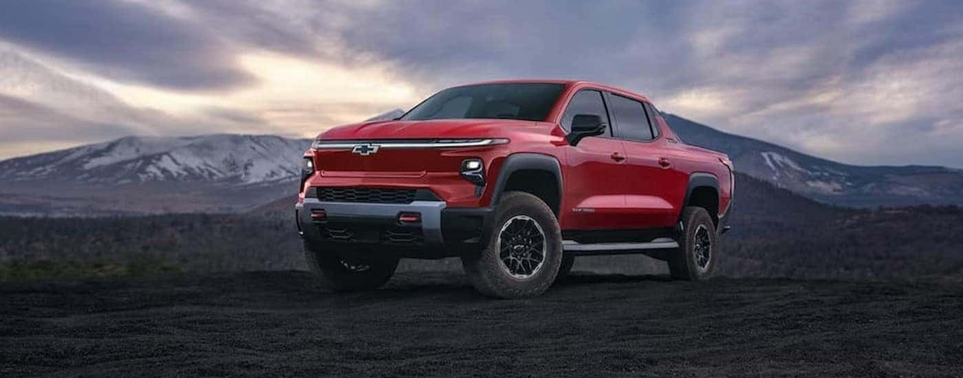 A red 2025 Chevy Silverado EV Trail Boss parked off-road.