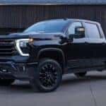 A black 2025 Chevy Silverado 3500 High Country parked on a driveway.
