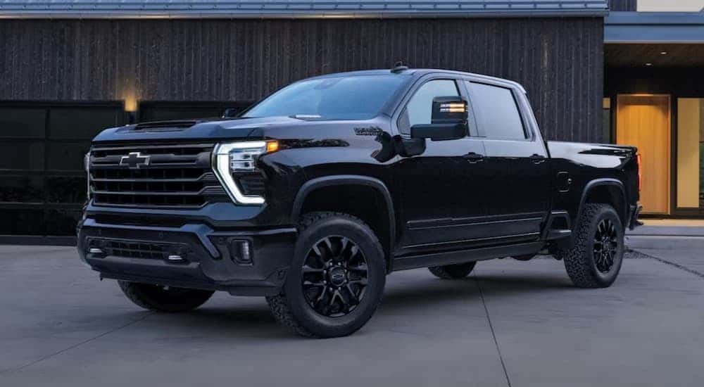 A black 2025 Chevy Silverado 3500 High Country parked on a driveway.