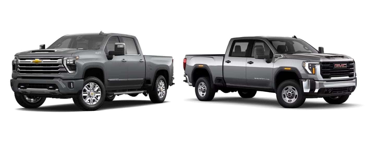Silver 2025 Chevy Silverado 2500 HD High Country angled left and silver 2025 GMC Sierra HD Pro angled right.