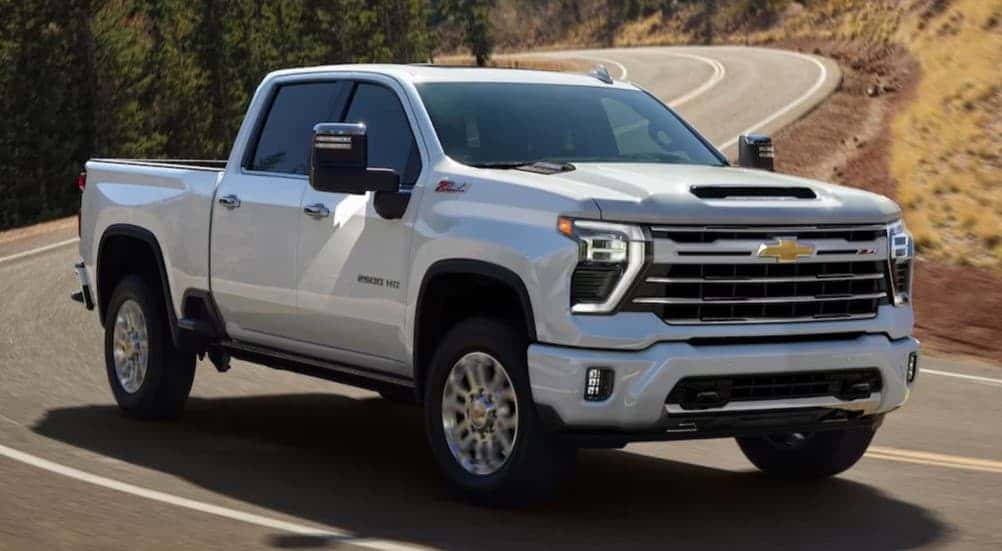 A white 2025 Chevy Silverado 2500 driving on a highway.