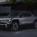 A silver 2025 Chevy Silverado EV charging in a garage