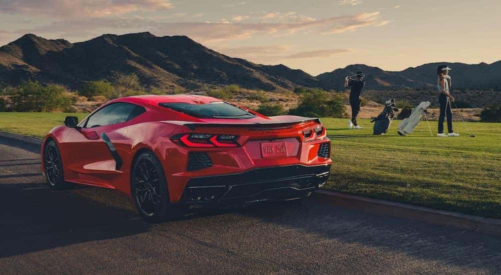 People golfing near a 2026 Chevy Corvette.