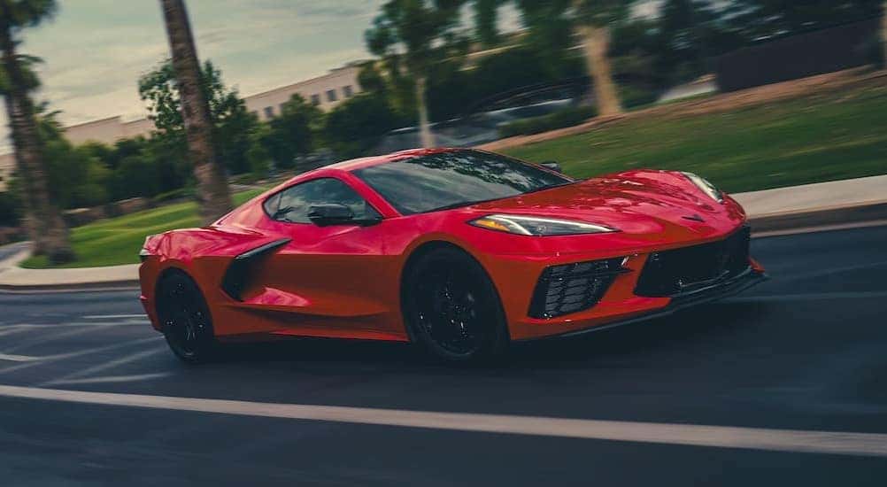 A red 2026 Chevy Corvette driving on a street.