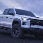 White 2025 Chevy Colorado for sale near Schenectady driving down a hill.
