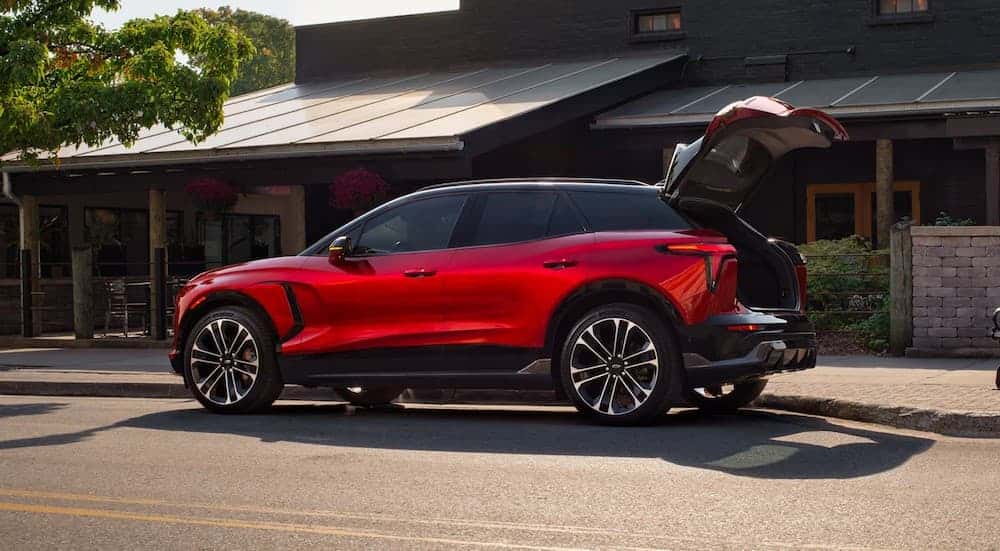 A red 2025 Chevy Blazer EV RS parked with its hatch open.