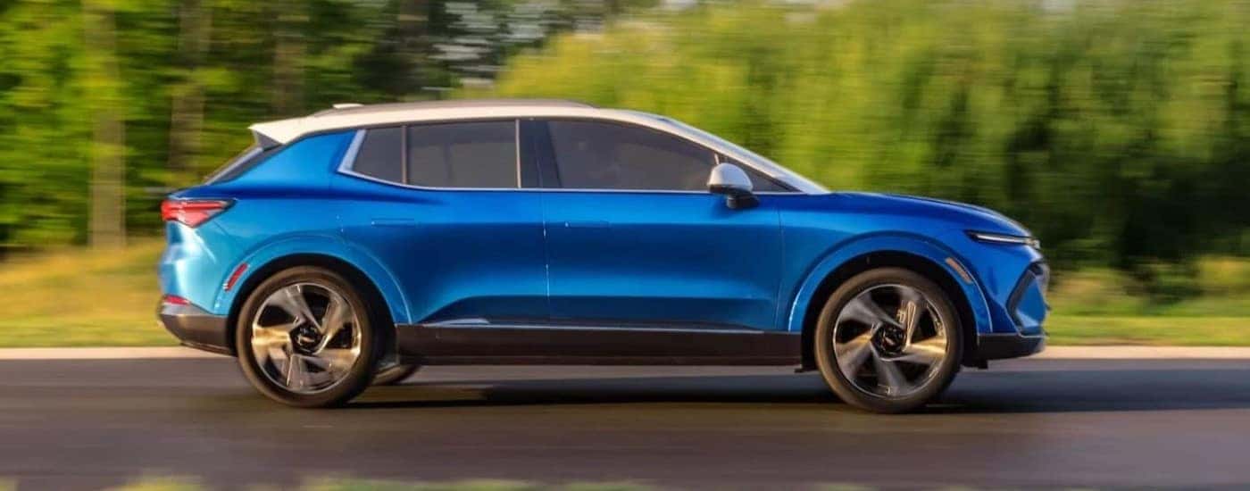 A blue 2024 Chevy Equinox EV driving down a street