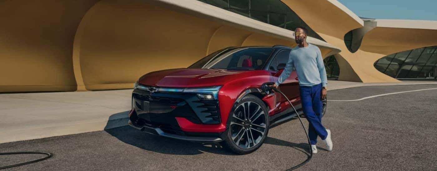 A red 2025 Chevy Blazer EV plugged in to charge